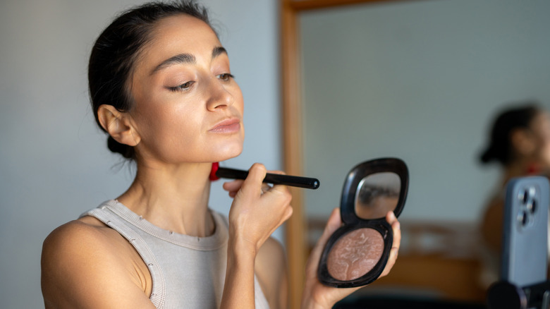 Femme appliquant une poudre bronzante