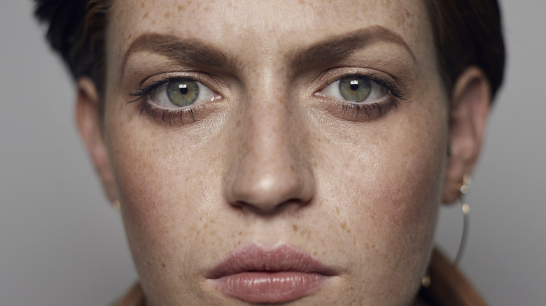 Une personne non binaire aux yeux gris perçants