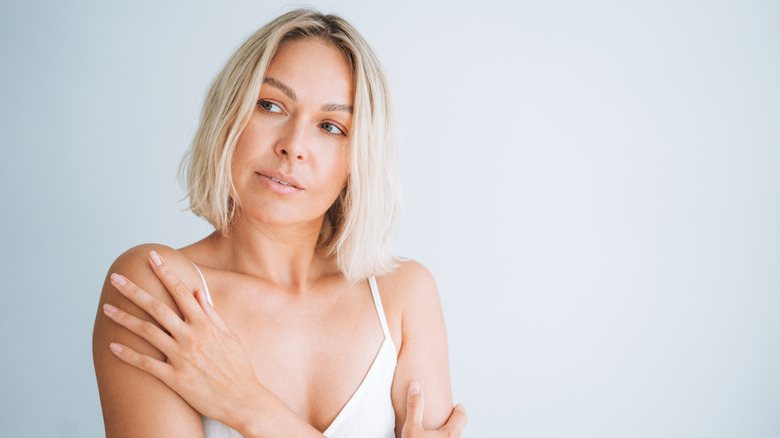 Une femme tenant ses épaules