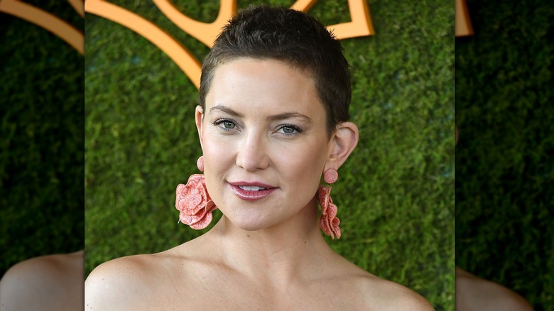 Kate Hudson avec un lutin marron et des boucles d'oreilles roses