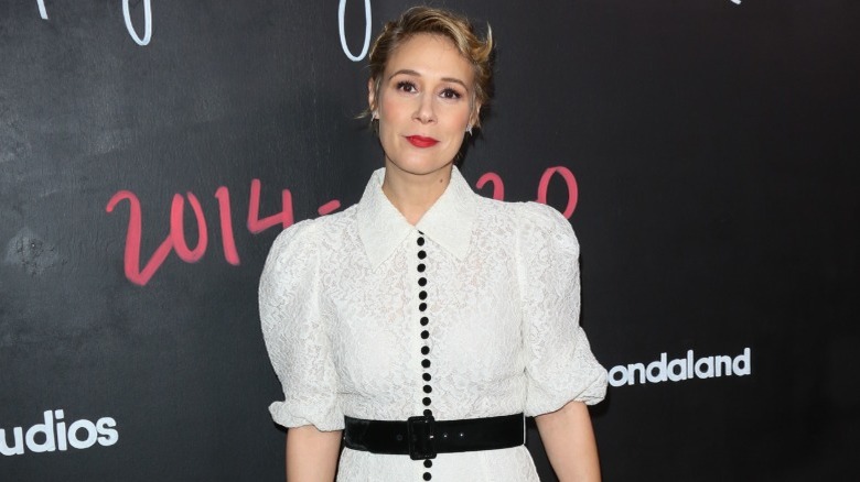 Liza Weil portant une robe blanche avec des détails noirs sur un tapis rouge en 2020.