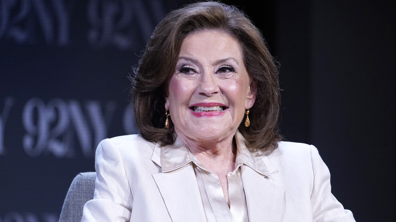 Kelly Bishop souriante en portant un costume blanc en 2025