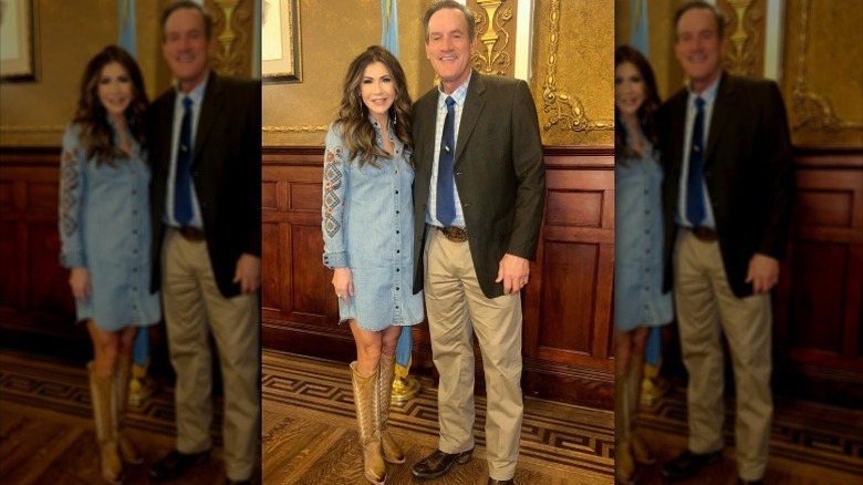 Kristi Noem pose pour une photo dans une robe en jean et des bottes de cowboy