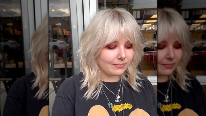 Une femme avec un shag blond et une frange de rideau