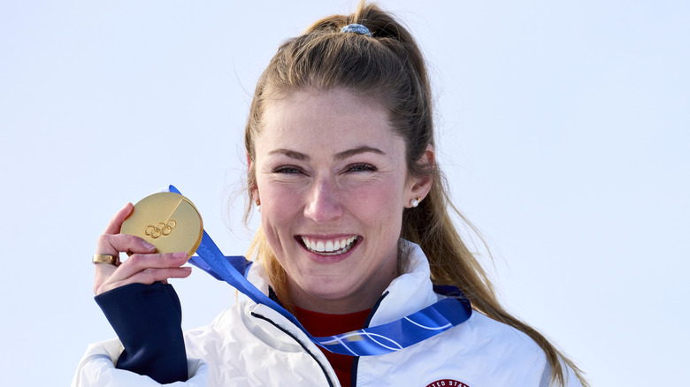 Mikaela Shiffrin sourit en montrant sa médaille d'or aux Jeux olympiques de 2026
