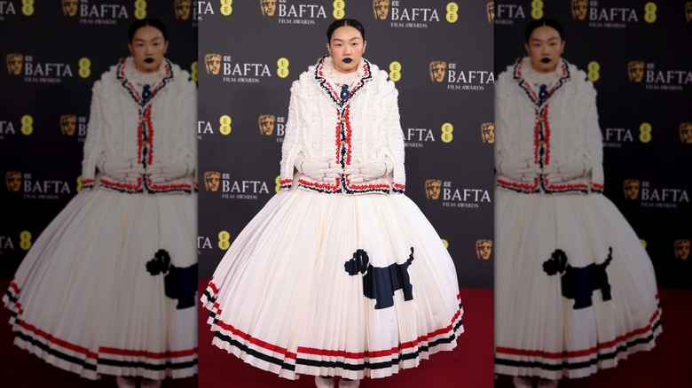 Audrey Nuna se tient sur le tapis rouge pendant que des photos sont prises