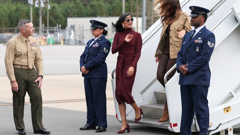 Usha Vance dans une robe bordeaux avec Melania Trump derrière elle