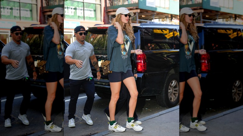 Taylor Swift dans la rue avec une casquette de baseball, un t-shirt surdimensionné et un short de vélo