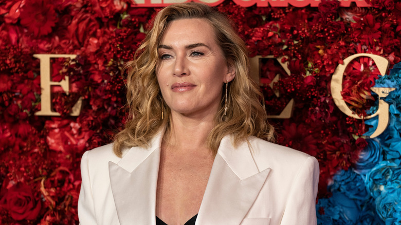 Kate Winslet posant devant un mur multimédia