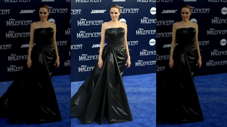 Angelina Jolie sourit dans une robe bustier en cuir.