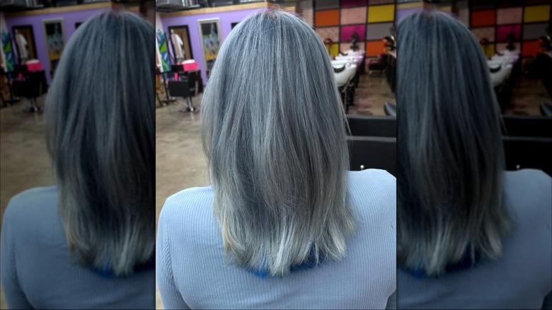Une femme aux cheveux gris rincés au bleu.