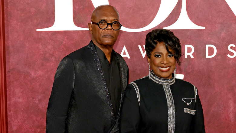 Samuel L. Jackson dans un costume noir métallisé, debout à côté de sa femme LaTanya Richardson, vêtue d'une robe noire et argentée.