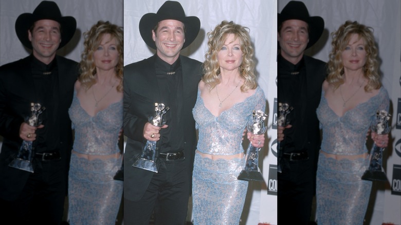 Clint Black portant une tenue entièrement noire et Lisa Hartman Black portant un ensemble deux pièces bleu brillant lors des ACM Awards 2000.