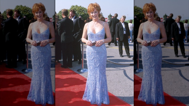 Reba McEntire posant sur un tapis rouge dans une robe bleue à fines bretelles lors des ACM Awards 2000.