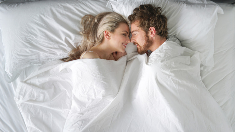 Un couple au lit se souriant