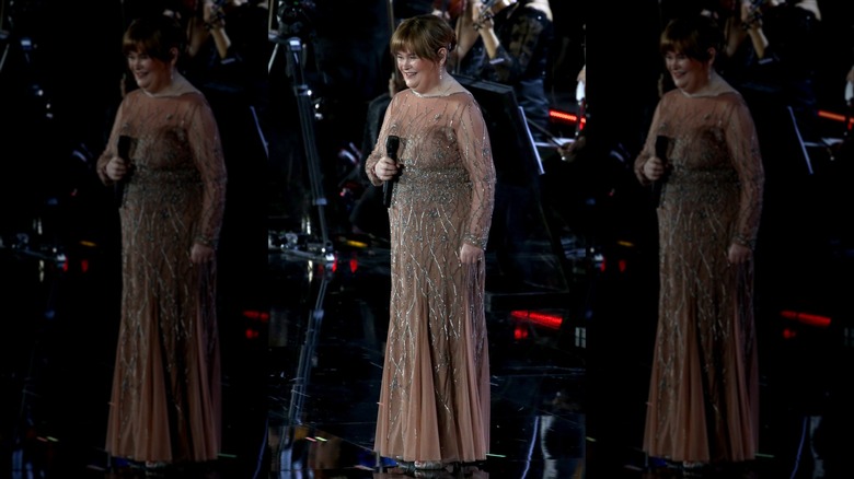 Susan Boyle tient un micro et porte une robe transparente ornée