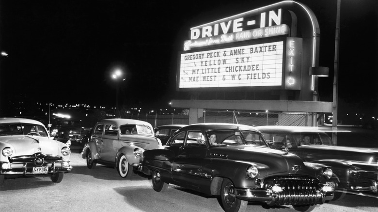 Photo en noir et blanc de voitures dans un ciné-parc