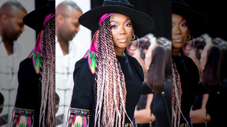 Brandy avec des tresses multicolores et un grand chapeau noir