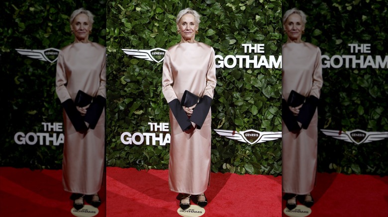 Laurie Metcalf posant sur un tapis rouge vêtue d'une robe en satin rose aux manches partiellement noires.