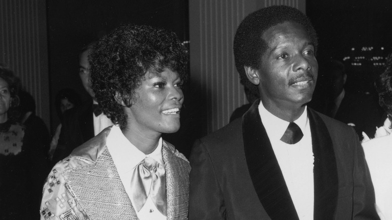 Photo en noir et blanc de Dionne Warwick marchant avec son mari, l'acteur américain William Elliott, en 1972.