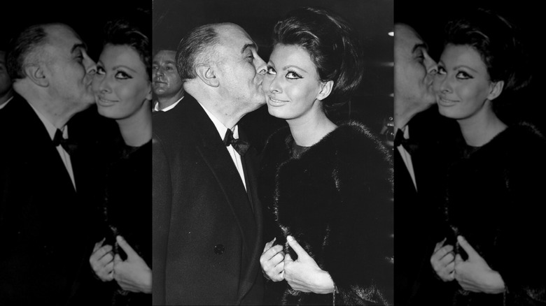 Photo en noir et blanc de Carlo Ponti embrassant sa femme, l'actrice Sophia Loren, en 1965.