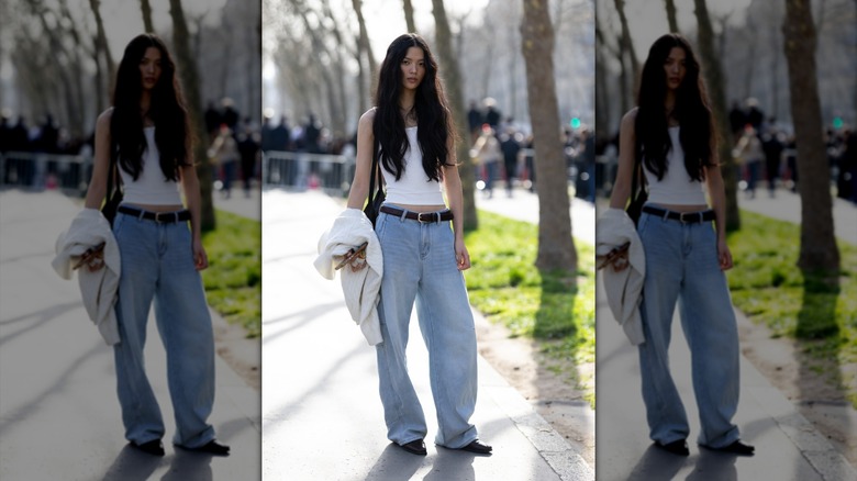 Une femme en jeans baggy et un débardeur