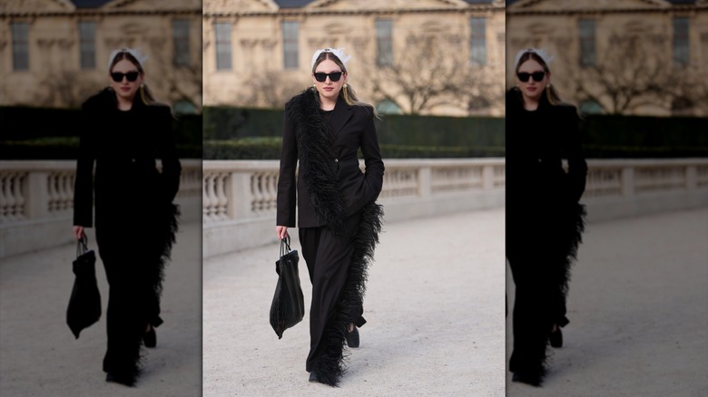 Une femme portant un costume noir avec des plumes