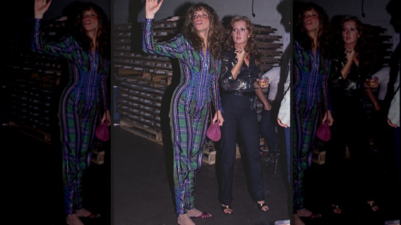 Carly Simon portant une combinaison à carreaux pour un spectacle, avec Bonnie Raitt à côté d'elle