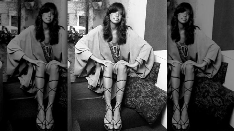Carly Simon pose pour un portrait en 1971 portant des sandales à lacets style gladiateur
