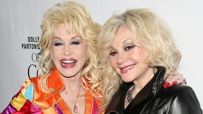 Dolly Parton rit en posant avec sa sœur Stella sur le tapis rouge.