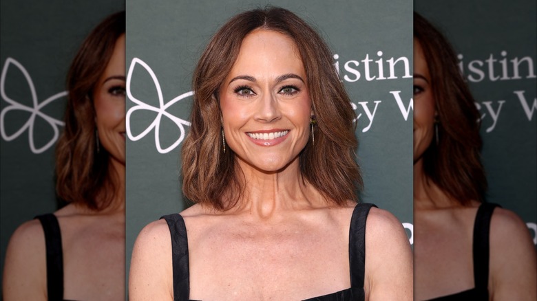 Nikki DeLoach sourit dans une robe noire