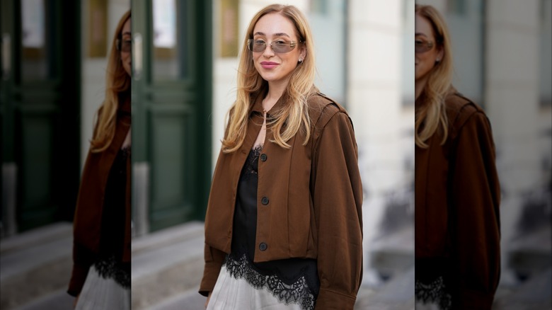 Sonia Lyson dans une veste marron et un caraco noir lors de la Fashion Week de Copenhague en août 2025.