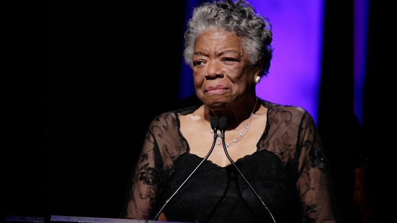 Maya Angelou se tient sur un podium alors qu'elle s'adresse à un public