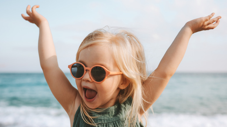 Une petite fille applaudit à la plage