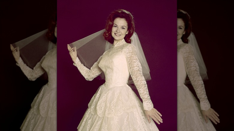 Shelley Fabares pose dans une robe de mariée en dentelle avec un voile court pour un portrait de 1965.