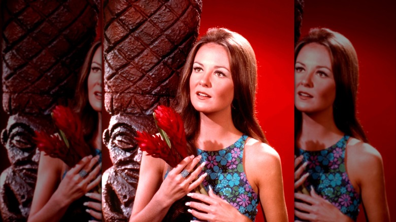 Shelley Fabares posant dans une robe à fleurs tenant des fleurs de gingembre dans un portrait vers 1965.