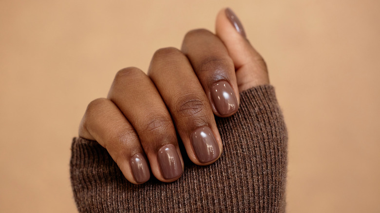 Gros plan d'une manucure de vernis à ongles marron.