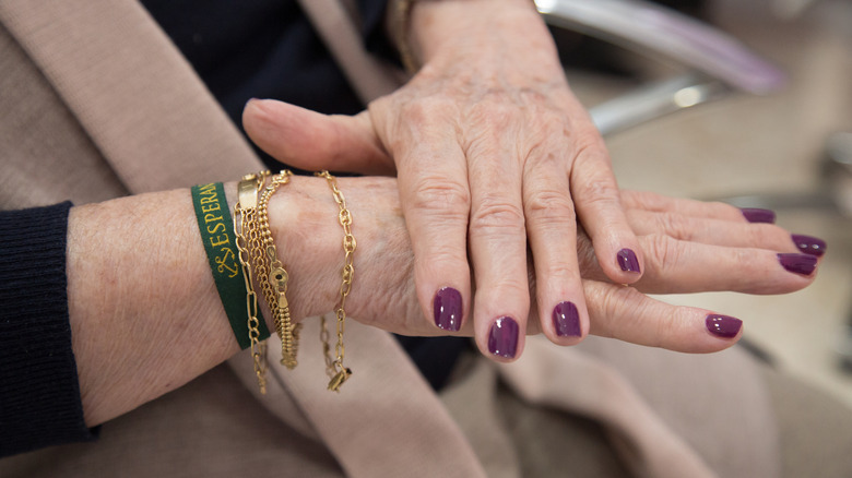 Une femme aux ongles violet foncé.