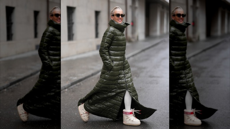 Une femme portant un long manteau vert avec un col cheminée.