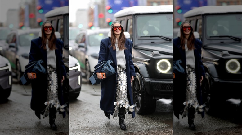 Une femme portant une jupe recouverte de sequins et des bottes souples