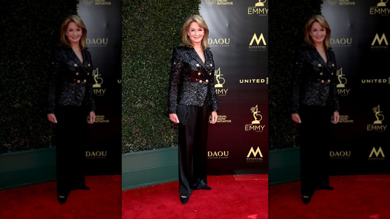 Deidre Hall sourit dans un blazer noir incrusté