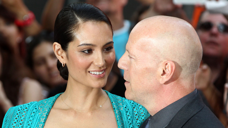 Emma Heming Willis et Bruce Willis se regardent avec amour dans les yeux lors d'une séance photo sur le tapis rouge.