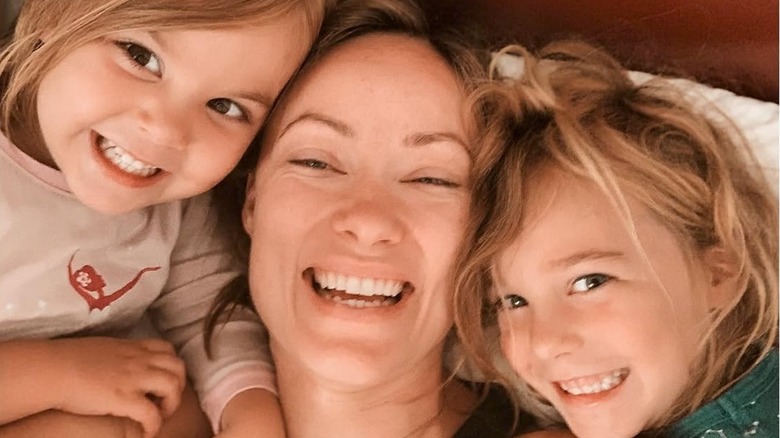 Olivia Wilde avec ses deux enfants souriants au lit en 2019.