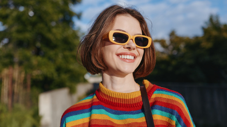 Une femme avec des lunettes de soleil et un carré rouge et émoussé