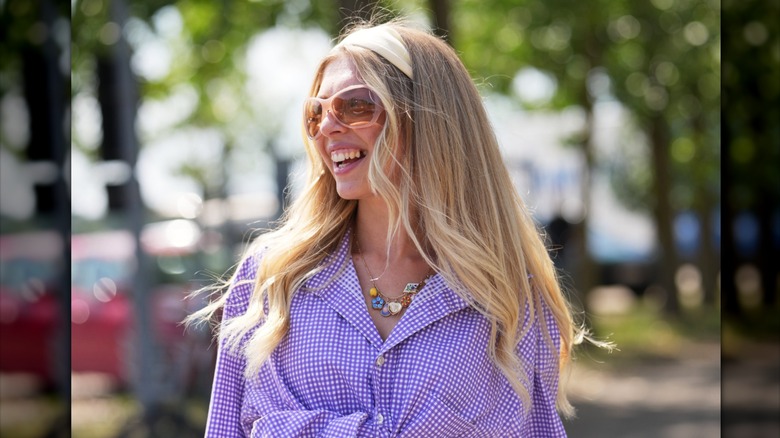 Une femme aux longs cheveux blonds superposés portant un bandeau