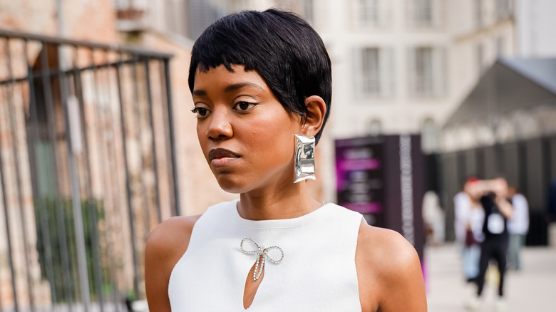 Une femme avec un lutin noir portant des boucles d'oreilles tendance