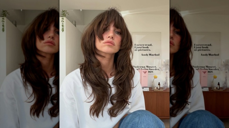Une personne avec une longue coupe brune ondulée