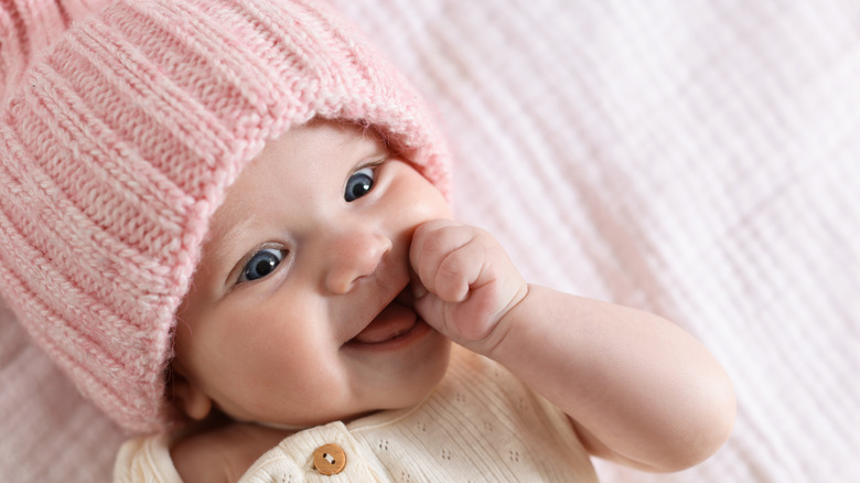 Bébé avec bonnet tricoté rose.