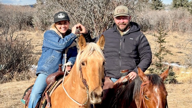 Amber et Shawn Marshall posent pour une photo en créant un cœur avec leurs mains lors d'une balade à cheval