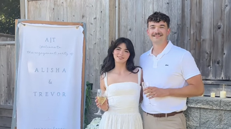 Alisha Newton et Trevor posent les bras l'un autour de l'autre lors de leur fête de fiançailles